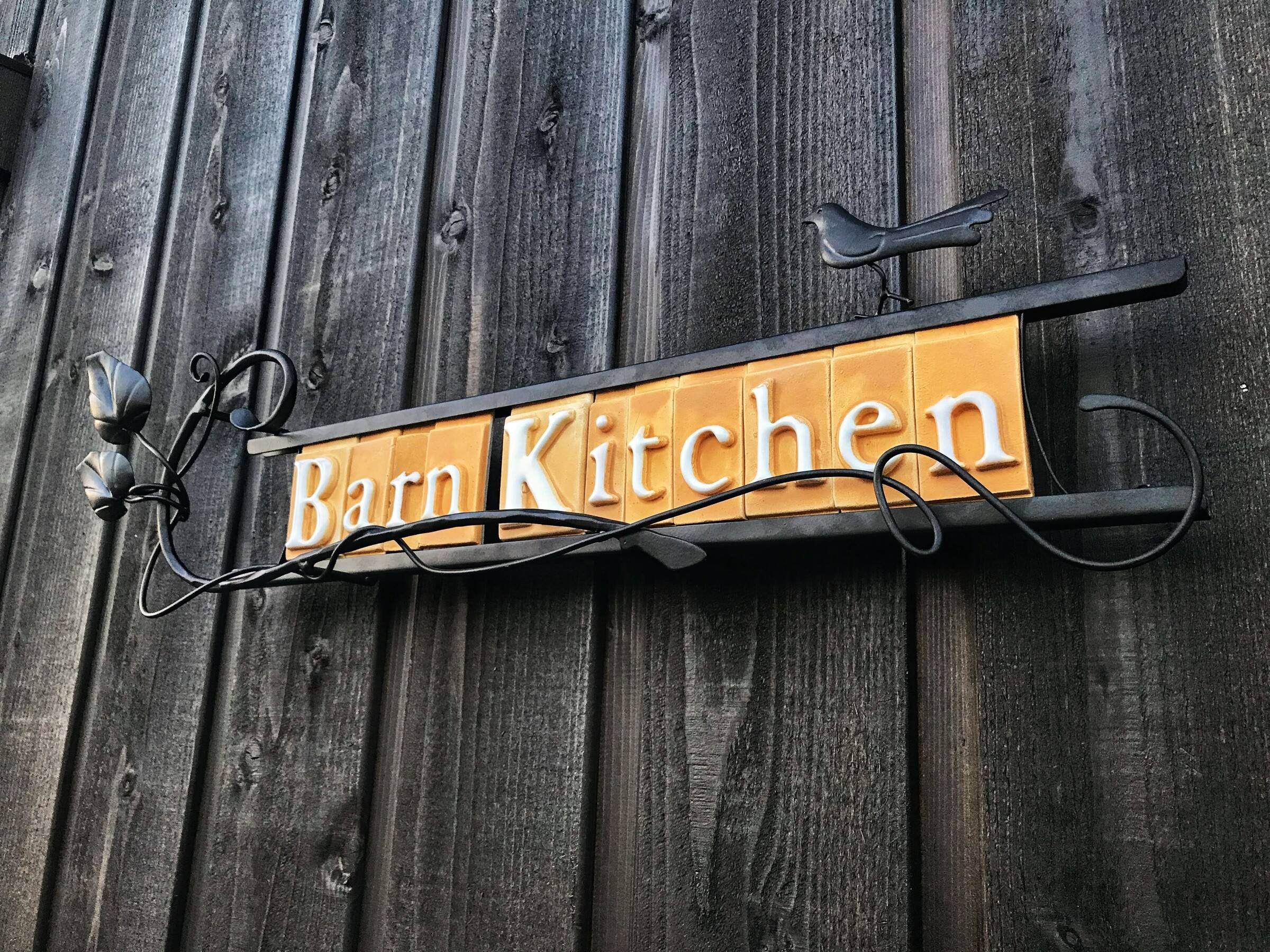 The hand-painted Barn Kitchen sign on dark timber